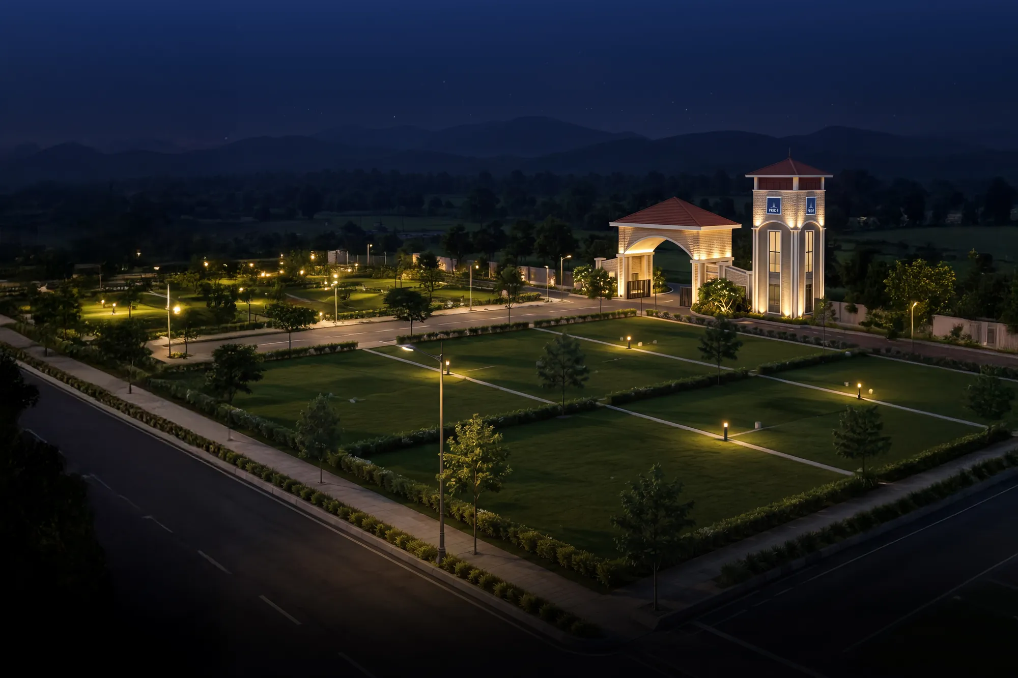 The lit internal roads and landscaped plots at night, with the clock tower beyond